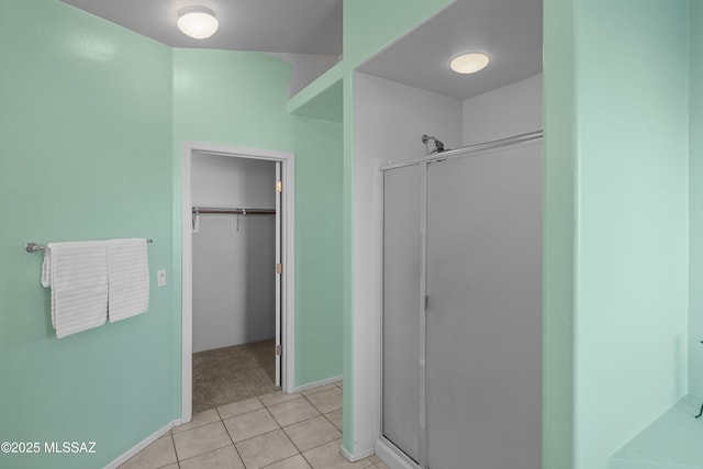 bathroom with an enclosed shower and tile patterned floors