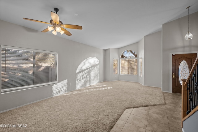 entryway featuring lofted ceiling, light tile patterned floors, plenty of natural light, and ceiling fan