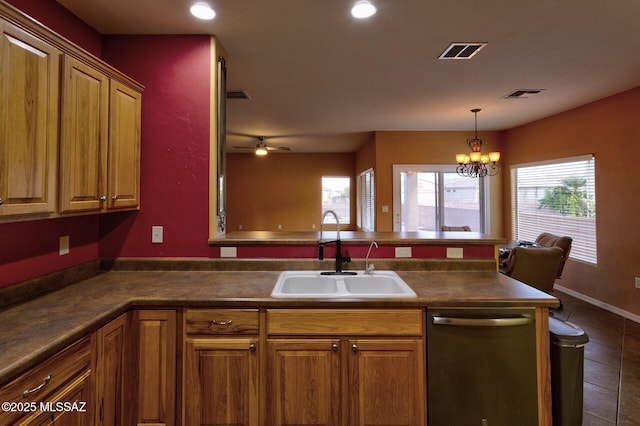 kitchen featuring ceiling fan with notable chandelier, dishwasher, sink, dark tile patterned flooring, and hanging light fixtures