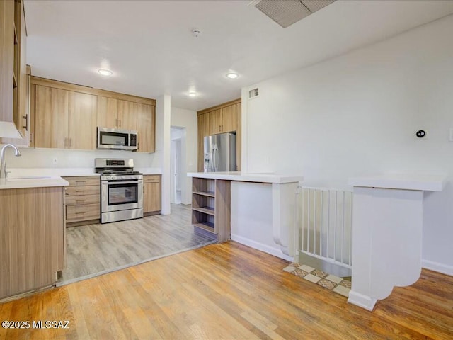 kitchen featuring light hardwood / wood-style floors, sink, light brown cabinets, and stainless steel appliances