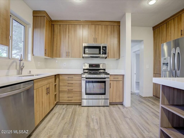 kitchen with sink, stainless steel appliances, light hardwood / wood-style flooring, and light brown cabinets