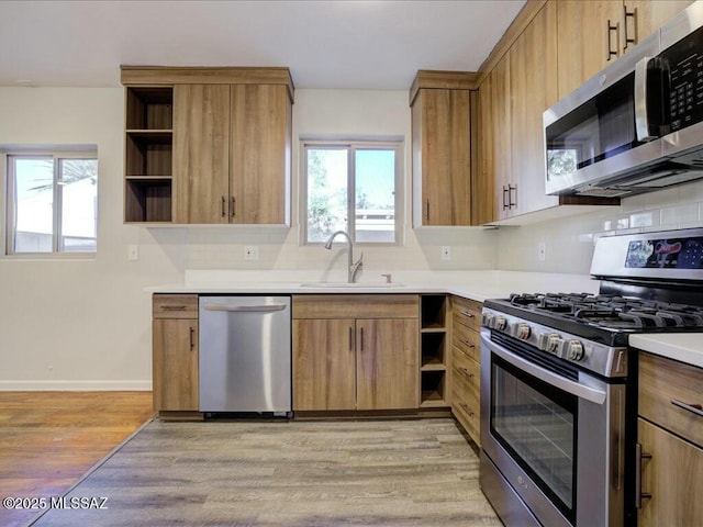 kitchen featuring sink, light wood-type flooring, and appliances with stainless steel finishes