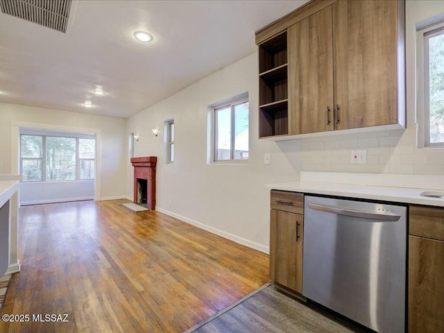 kitchen with hardwood / wood-style flooring, backsplash, dishwasher, and a healthy amount of sunlight