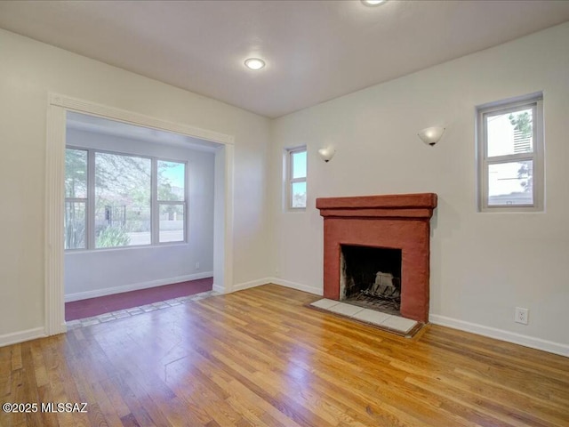 unfurnished living room with a fireplace and light hardwood / wood-style floors