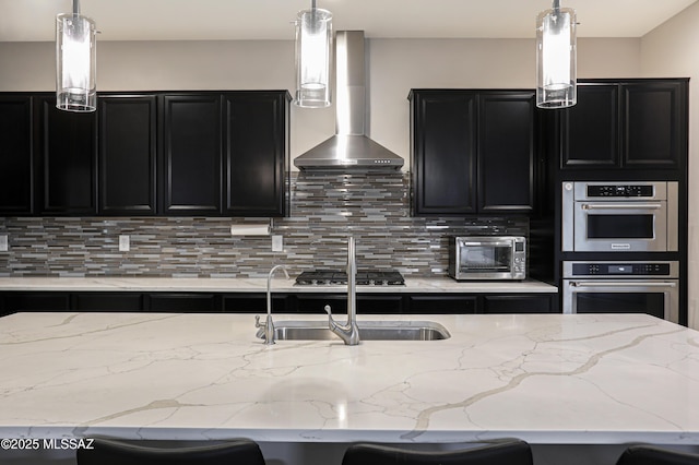 kitchen featuring wall chimney range hood, backsplash, a kitchen breakfast bar, and stainless steel appliances