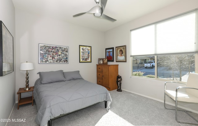 bedroom featuring ceiling fan, multiple windows, and light carpet