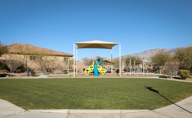 view of jungle gym with a mountain view and a lawn