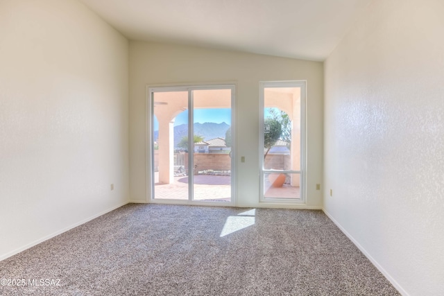 empty room featuring carpet floors and vaulted ceiling