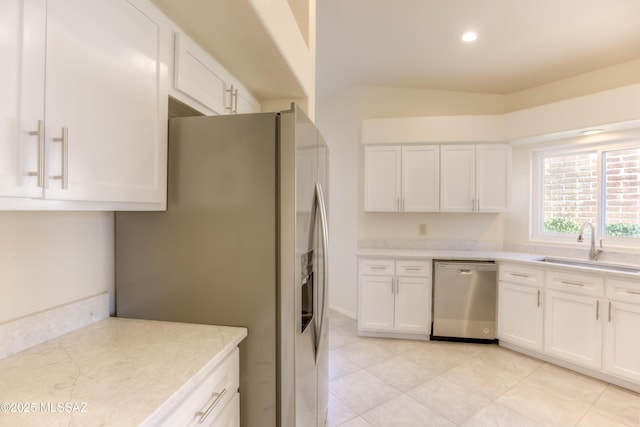 kitchen featuring white cabinets, stainless steel appliances, light tile patterned flooring, and sink