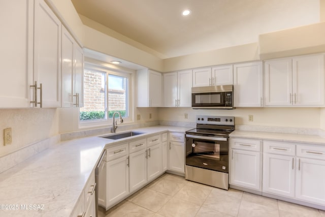 kitchen featuring light tile patterned floors, sink, white cabinetry, and appliances with stainless steel finishes