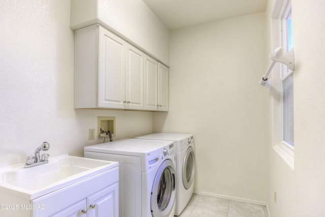 laundry room featuring light tile patterned floors, cabinets, washer and clothes dryer, and sink