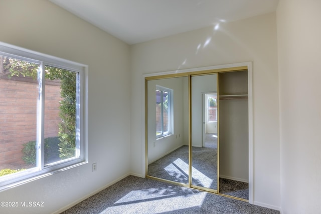 unfurnished bedroom featuring a closet, carpet floors, and multiple windows