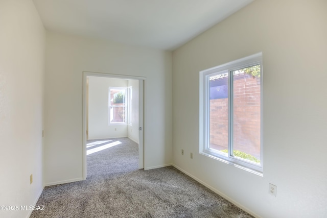 spare room featuring plenty of natural light and light colored carpet