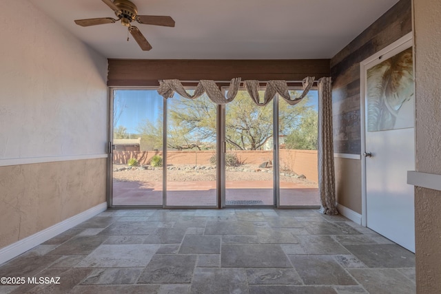 unfurnished sunroom with ceiling fan and a wealth of natural light