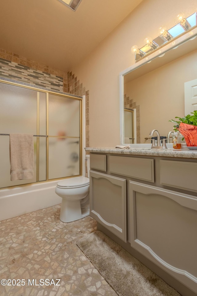 bathroom with toilet, vanity, and enclosed tub / shower combo