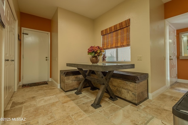 dining room with stone finish floor and baseboards