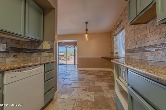 kitchen with stone tile floors, white dishwasher, and green cabinetry