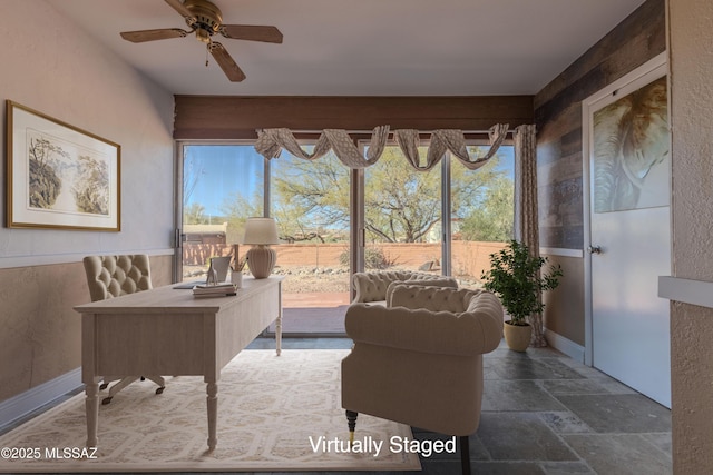 office space with ceiling fan and stone tile floors