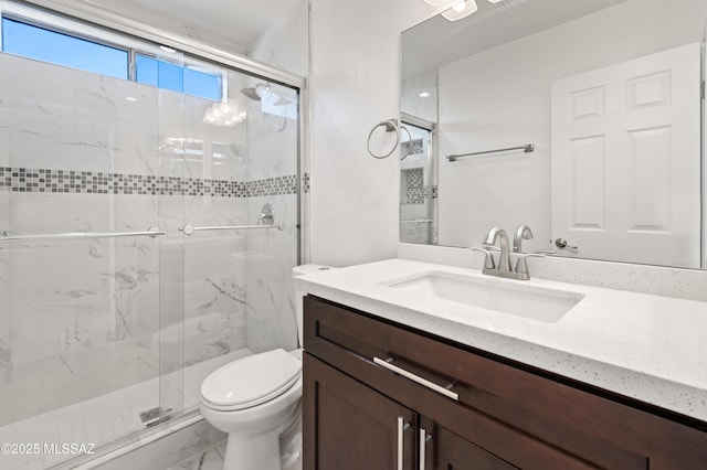 bathroom featuring vanity, an enclosed shower, and toilet