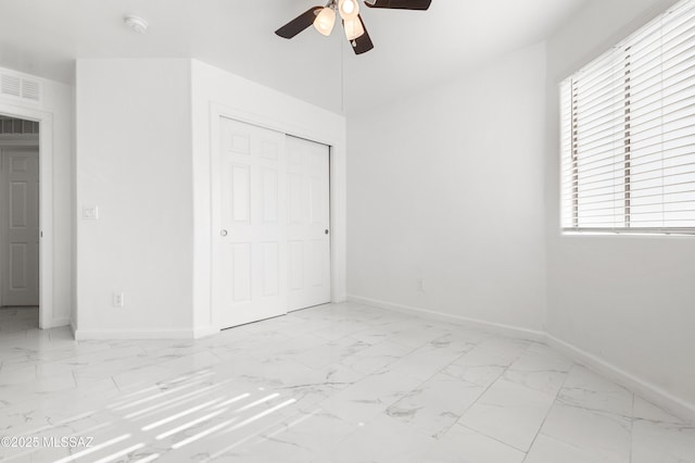 unfurnished bedroom featuring ceiling fan and a closet