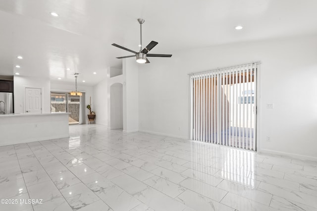 unfurnished living room featuring ceiling fan and a wealth of natural light