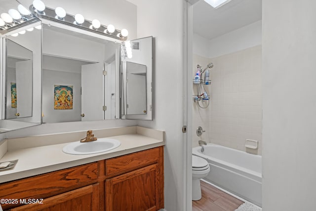 full bathroom with vanity, hardwood / wood-style flooring, shower / tub combination, and toilet