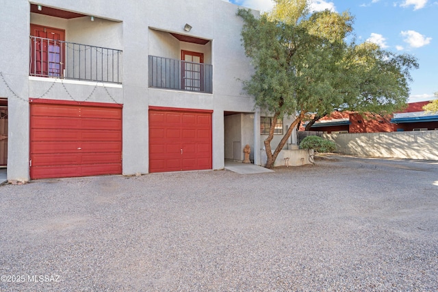 view of front of property featuring a garage and a balcony