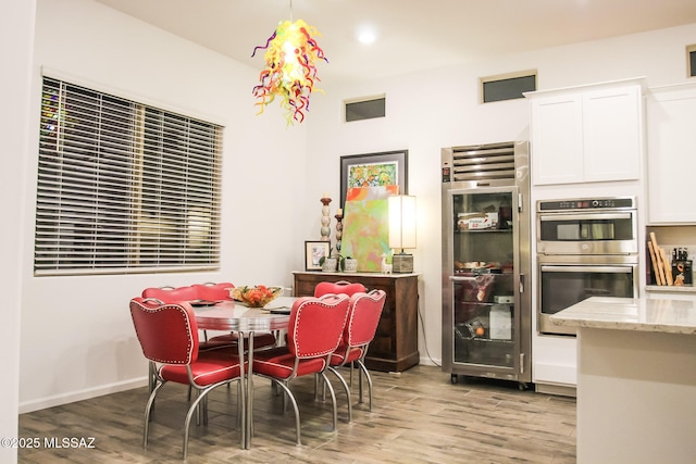 dining space featuring light hardwood / wood-style floors and beverage cooler