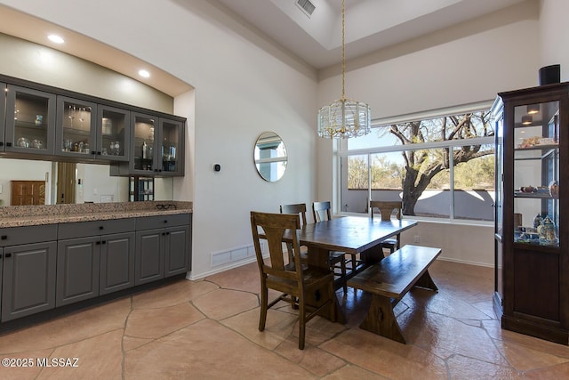 dining space with a notable chandelier and a towering ceiling