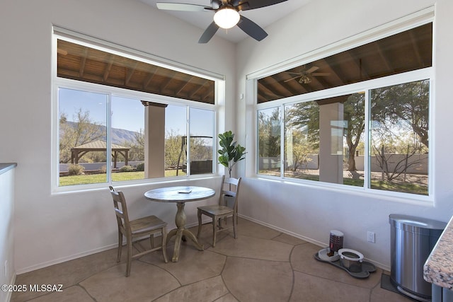 sunroom / solarium featuring ceiling fan, a mountain view, and wood ceiling