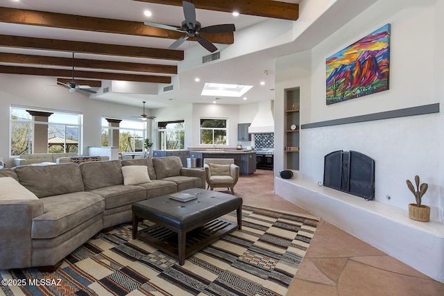 tiled living room featuring sink, beam ceiling, and a skylight