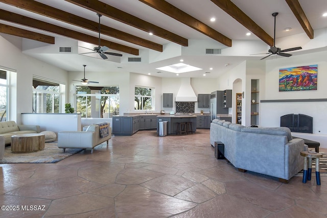 living room with sink, beam ceiling, and a wealth of natural light