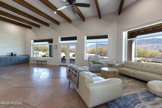 living room with french doors, ceiling fan, beam ceiling, and a mountain view