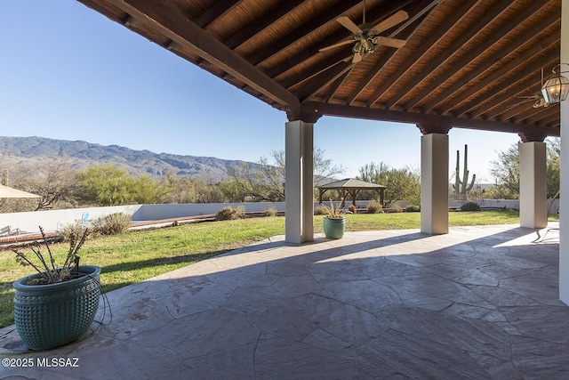 view of patio with a mountain view, a gazebo, and ceiling fan