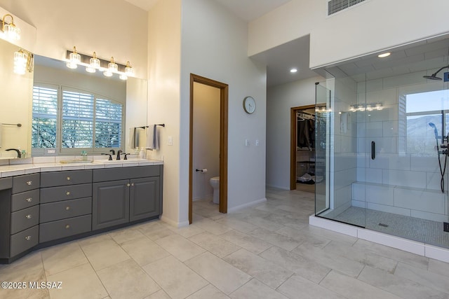 bathroom featuring vanity, tile patterned floors, a shower with door, and toilet