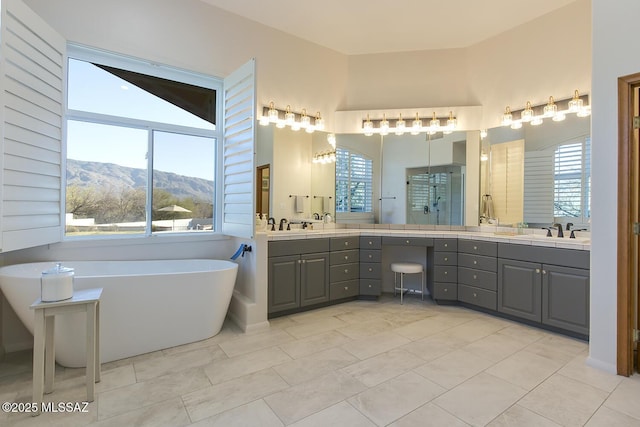 bathroom with independent shower and bath, vanity, a mountain view, and tile patterned floors