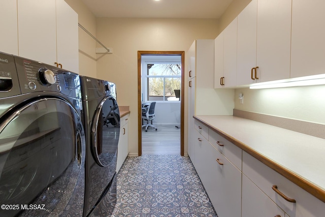 laundry room with cabinets and washer and clothes dryer