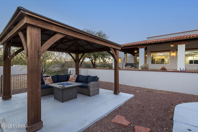 patio terrace at dusk with a gazebo and an outdoor living space with a fire pit