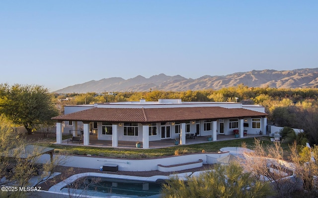 rear view of property featuring a patio and a mountain view