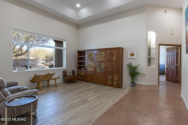 living area with a high ceiling and light hardwood / wood-style flooring