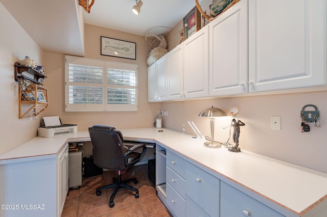 home office featuring built in study area and light tile patterned floors