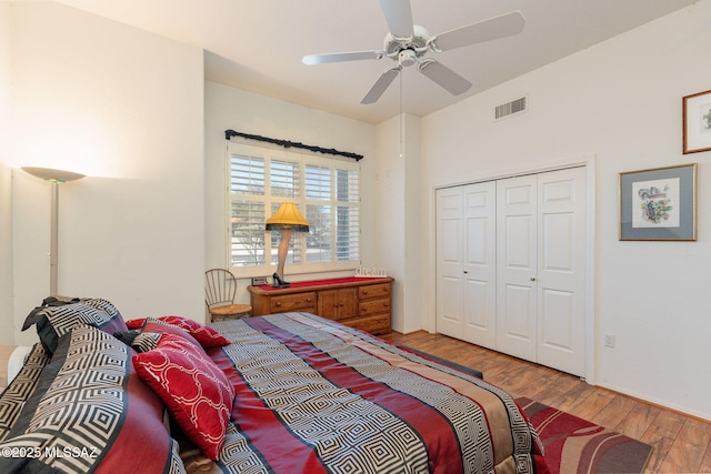 bedroom featuring ceiling fan, a closet, visible vents, and wood finished floors