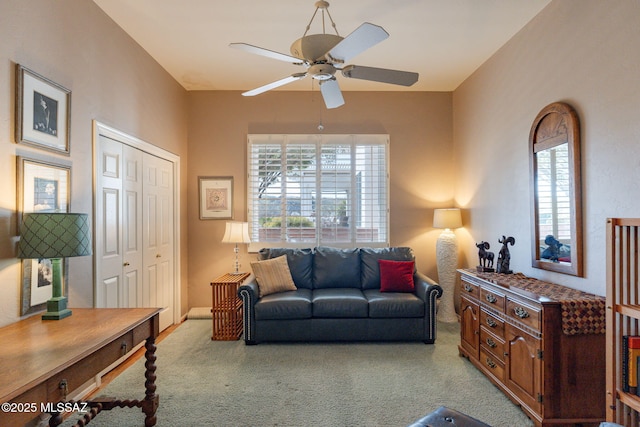 carpeted living room with ceiling fan