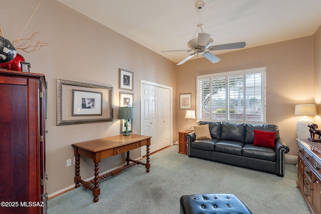 carpeted living area featuring a ceiling fan and baseboards