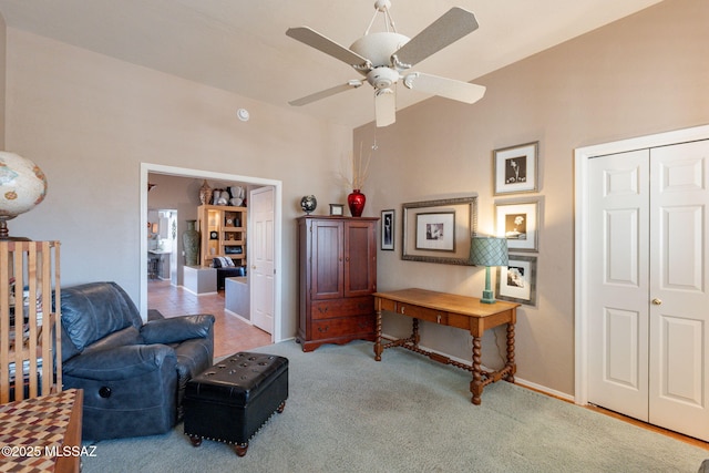 sitting room featuring carpet, vaulted ceiling, baseboards, and ceiling fan