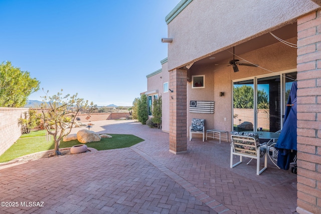 view of patio featuring a ceiling fan and fence