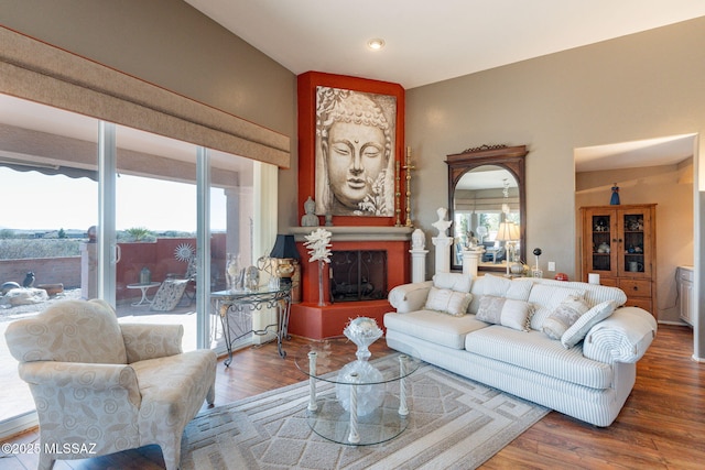 living room with plenty of natural light, a fireplace, and wood finished floors