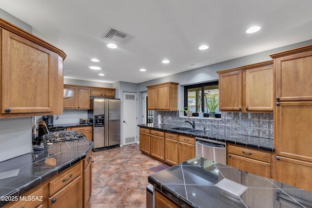 kitchen featuring stainless steel appliances, sink, exhaust hood, and decorative backsplash