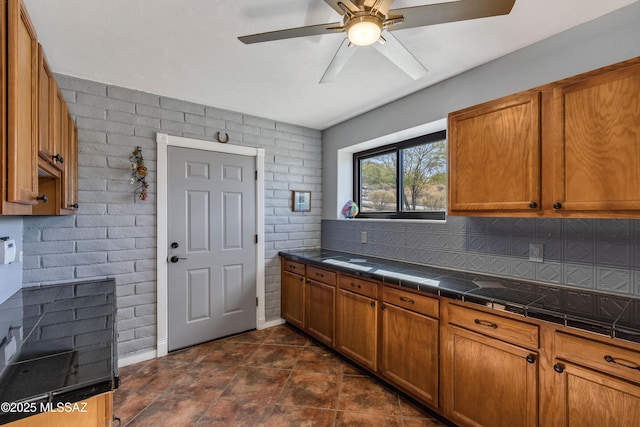 kitchen with ceiling fan and brick wall