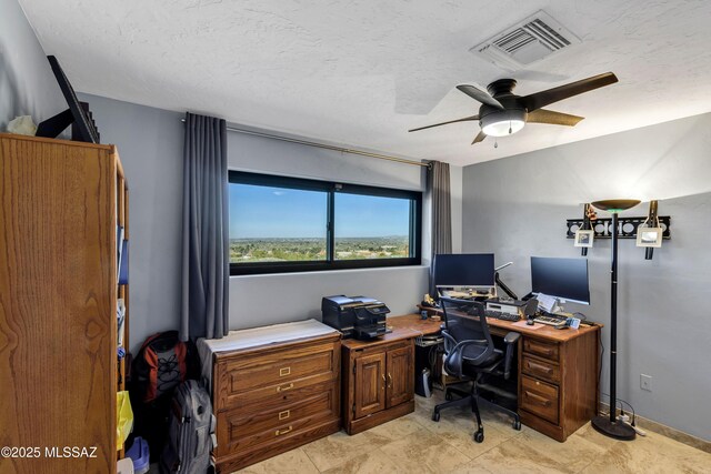 home office featuring ceiling fan and a textured ceiling